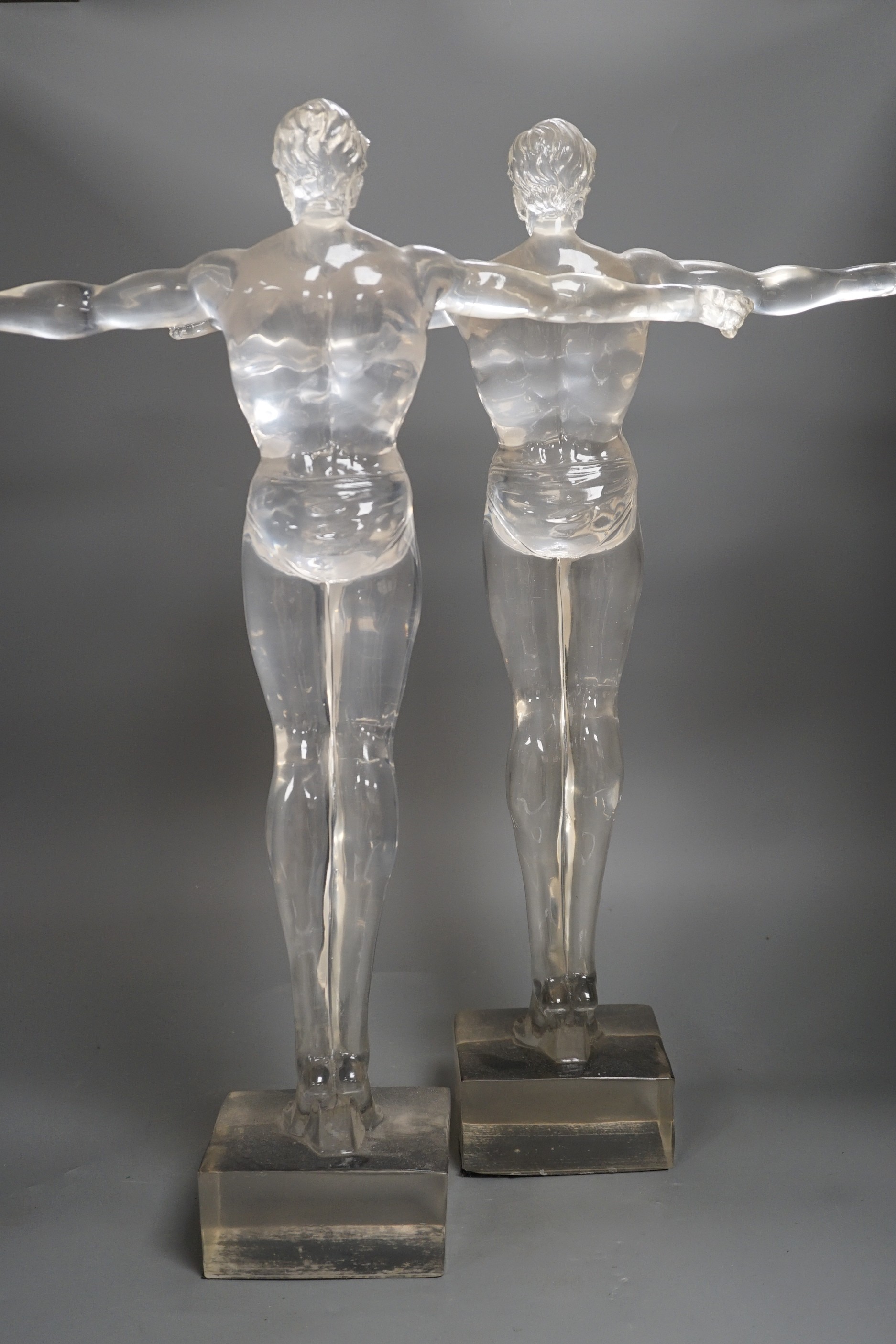 A pair of clear perspex models of male swimmers, 57cms high